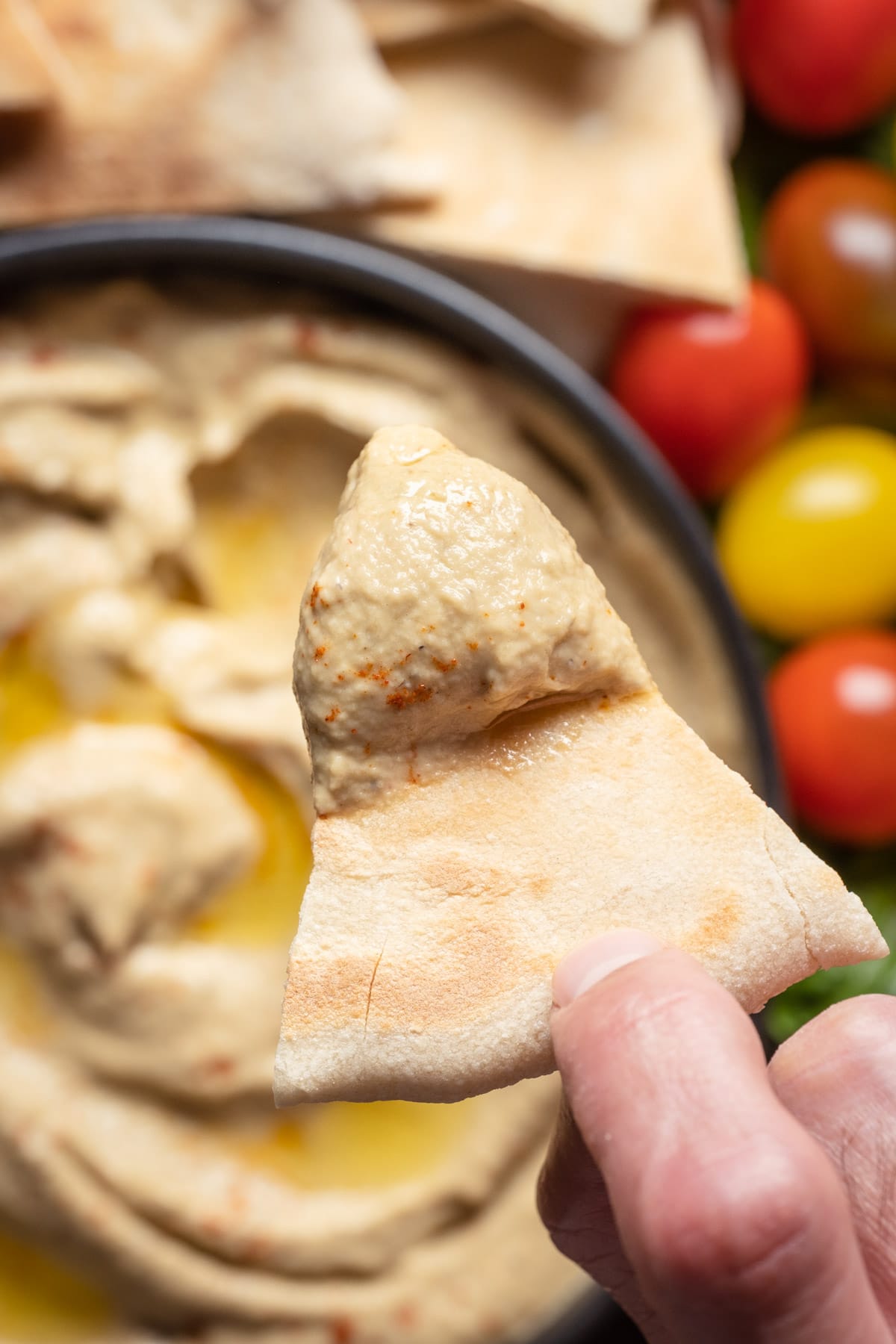 Pita bread dipped into a bowl of baba ganoush.