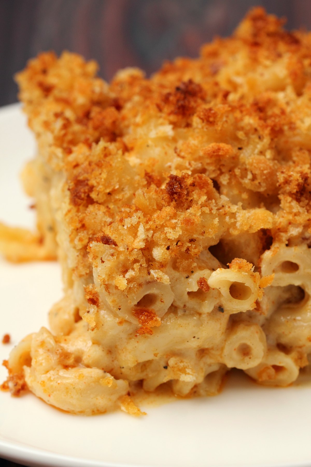 A slice of vegan mac and cheese on a white plate. 