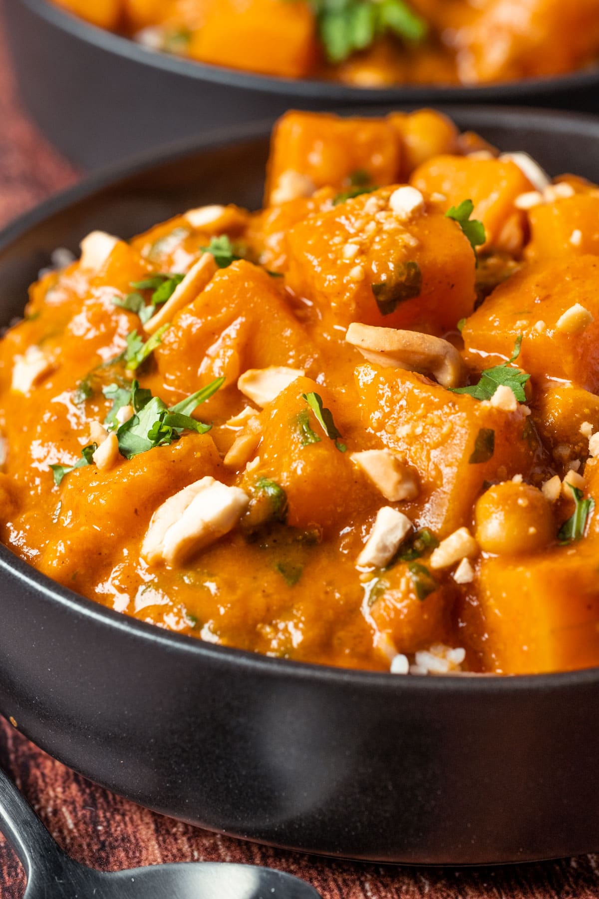 Vegan butternut squash curry and rice in a black bowl.