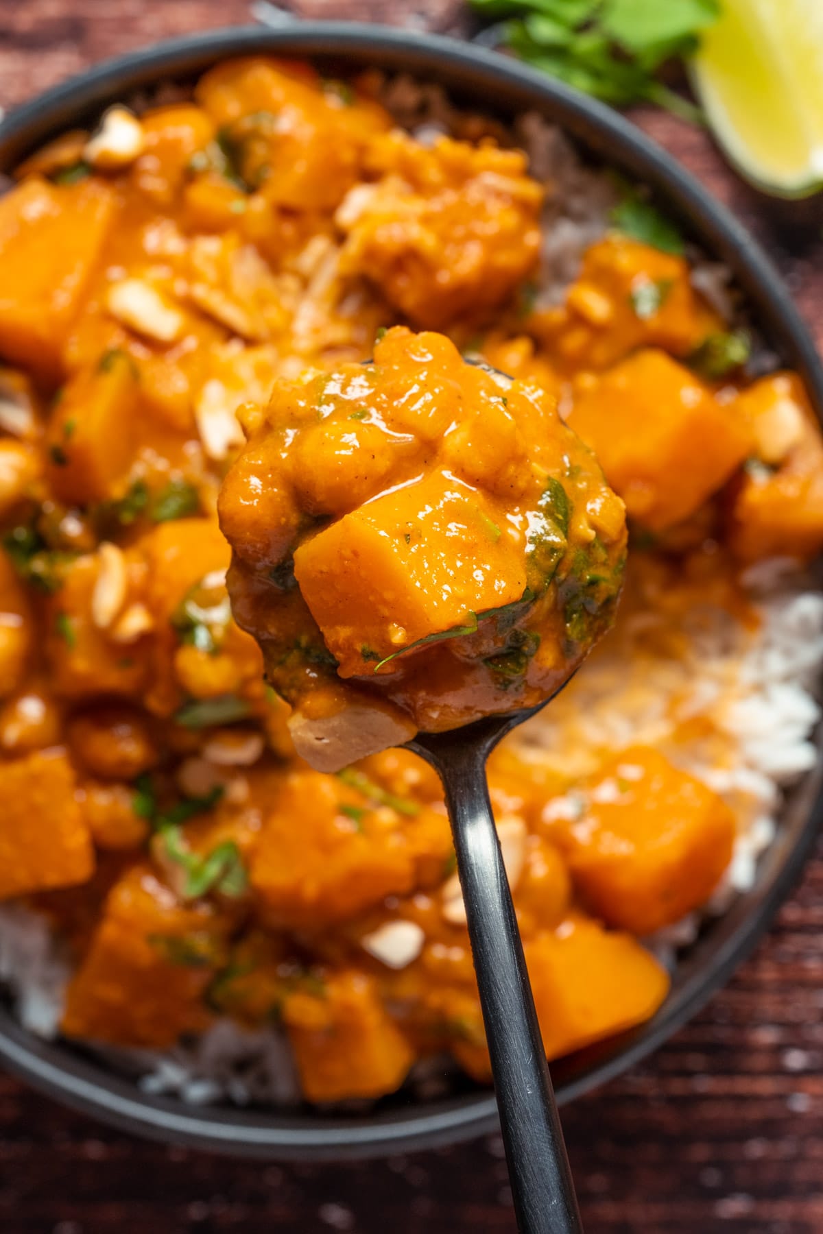 Butternut squash curry and rice in a black bowl with a rice.