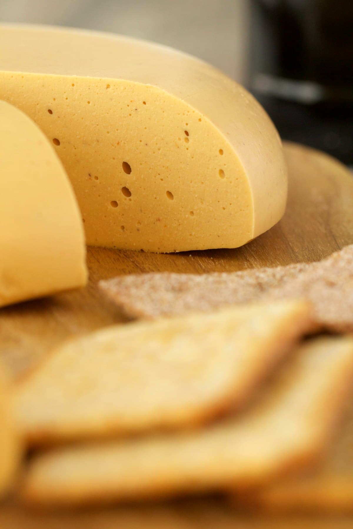 Cashew Cheese on a wooden board with crackers. 