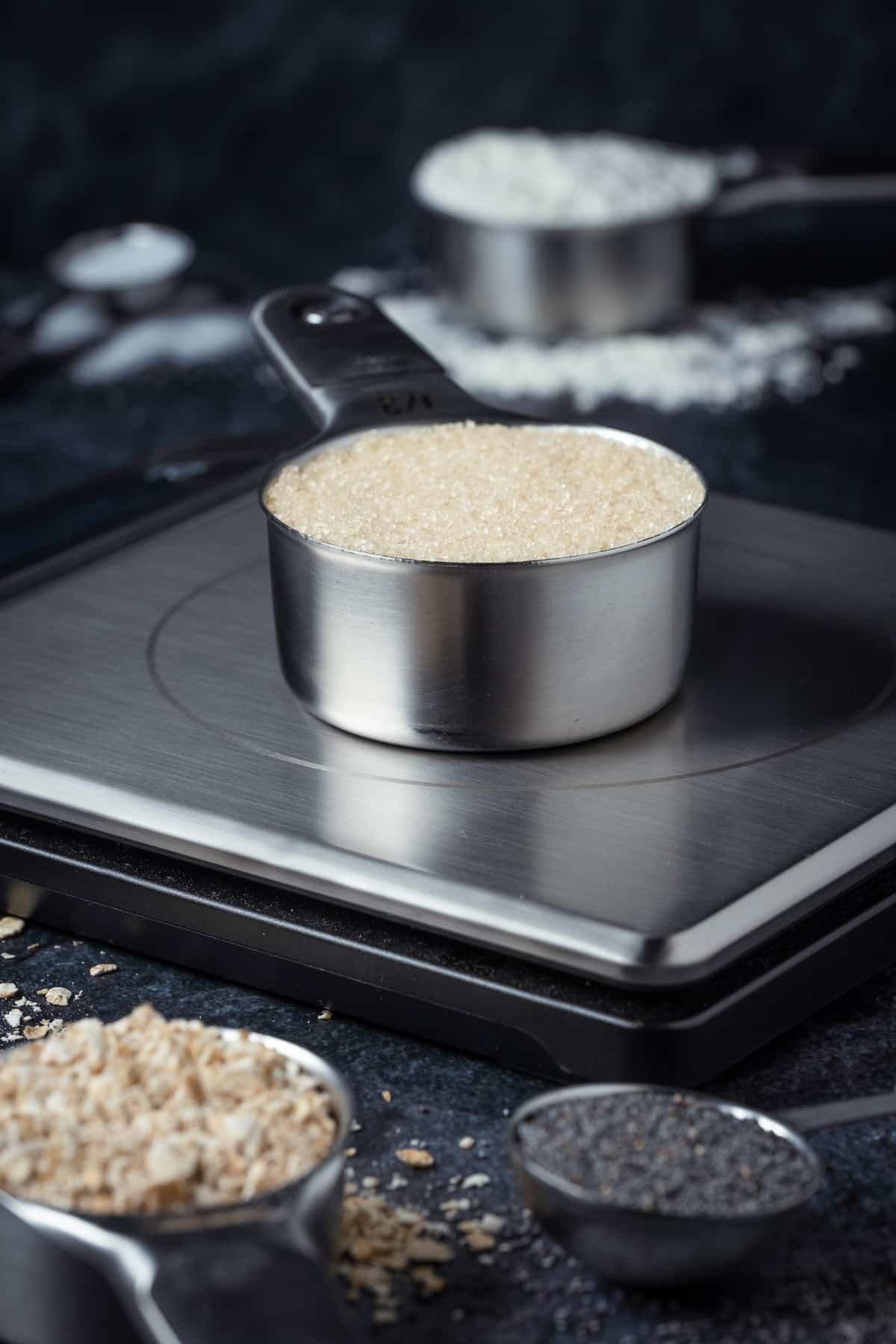 Measuring cup filled with brown sugar on a kitchen scale. 