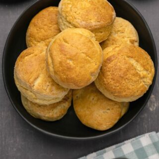 Vegan biscuits stacked up on a black plate.