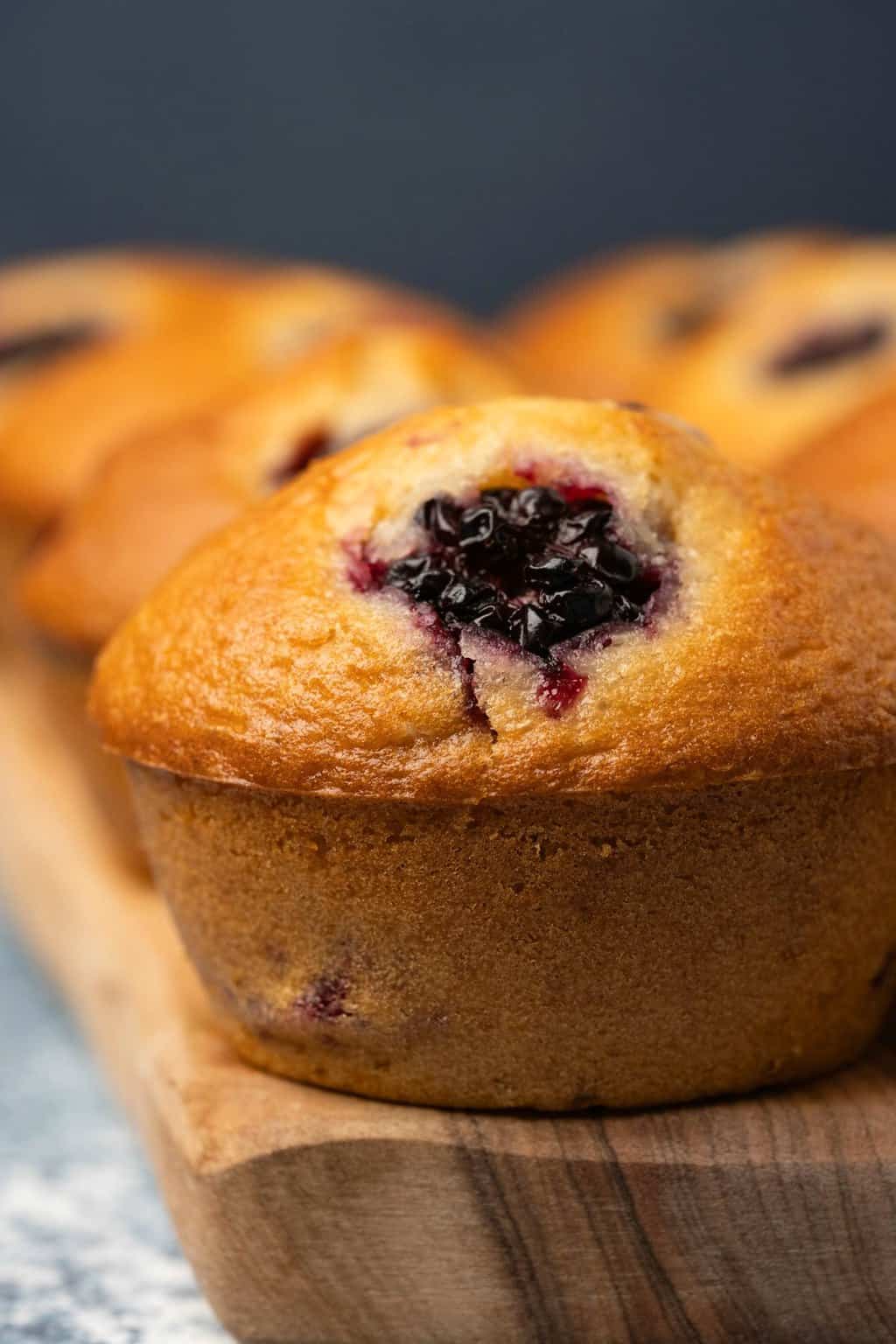 Vegan blackberry muffins on a wooden board. 