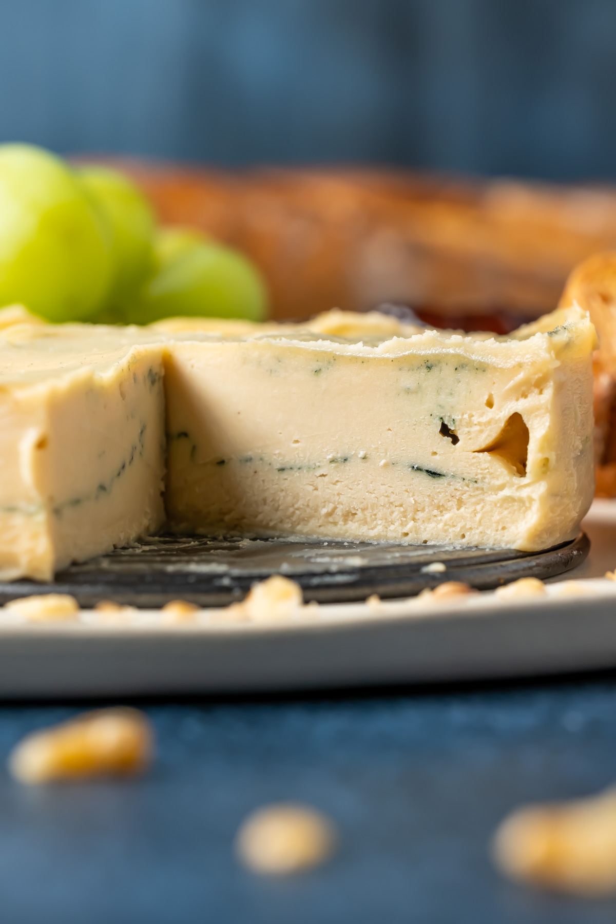 Vegan blue cheese on a white plate with toasted bread, walnuts, grapes and jams.