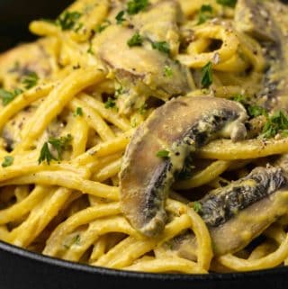 Vegan carbonara in a black bowl.