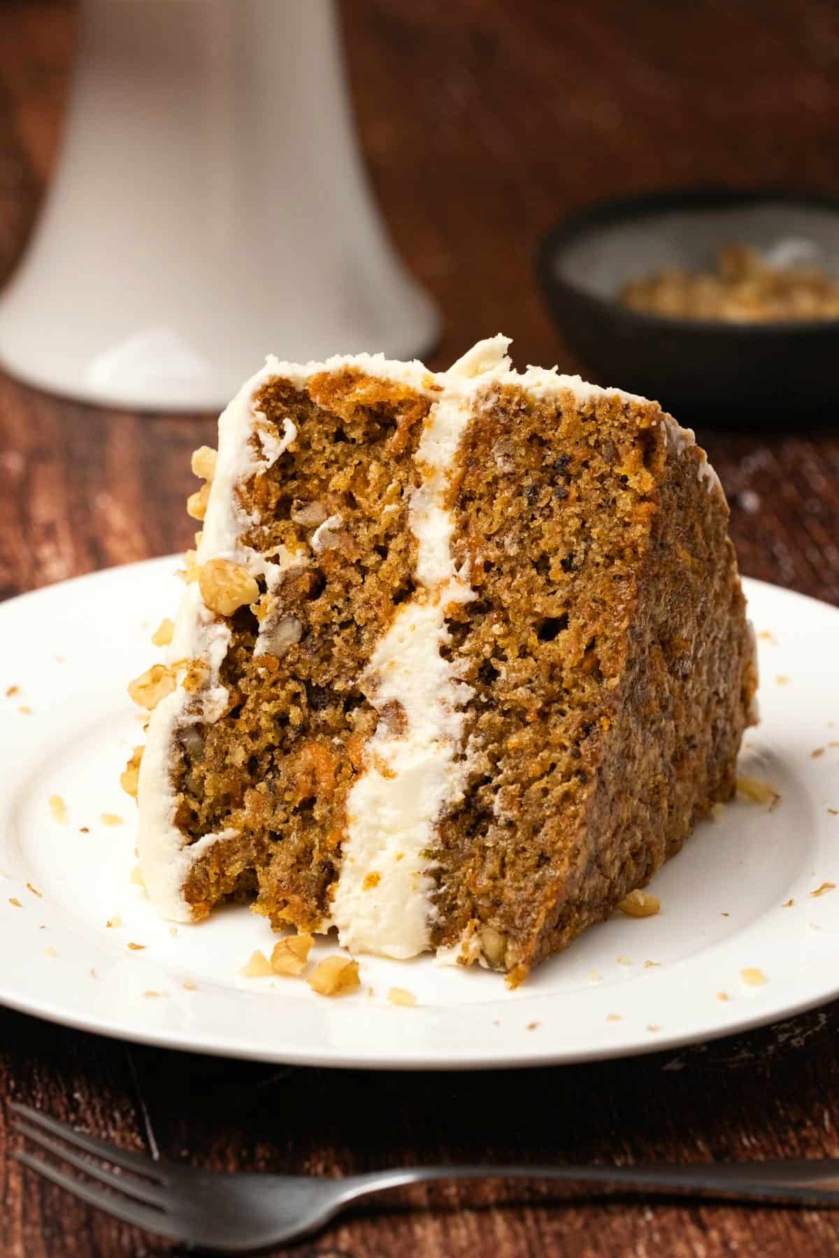 Slice of vegan carrot cake on a white plate.