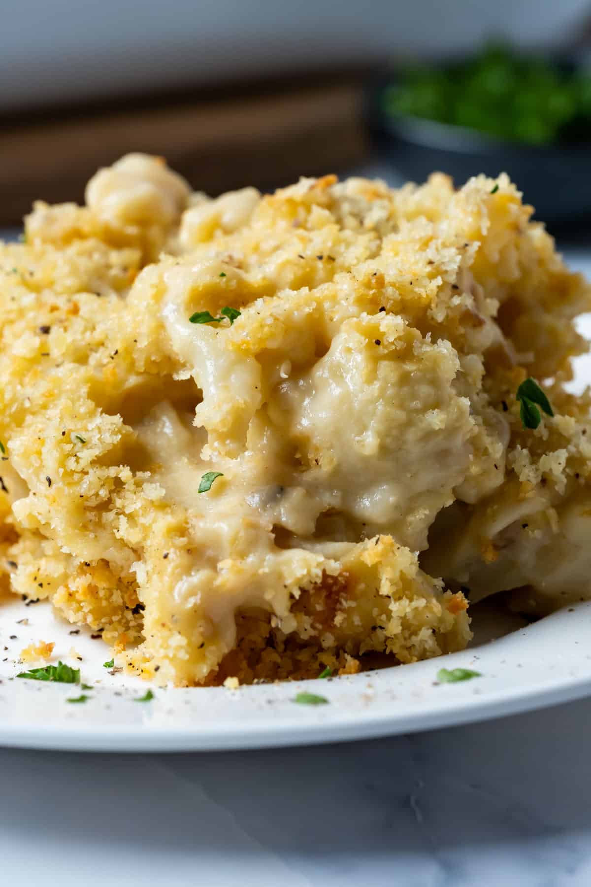 Serving of vegan cauliflower cheese on a white plate.