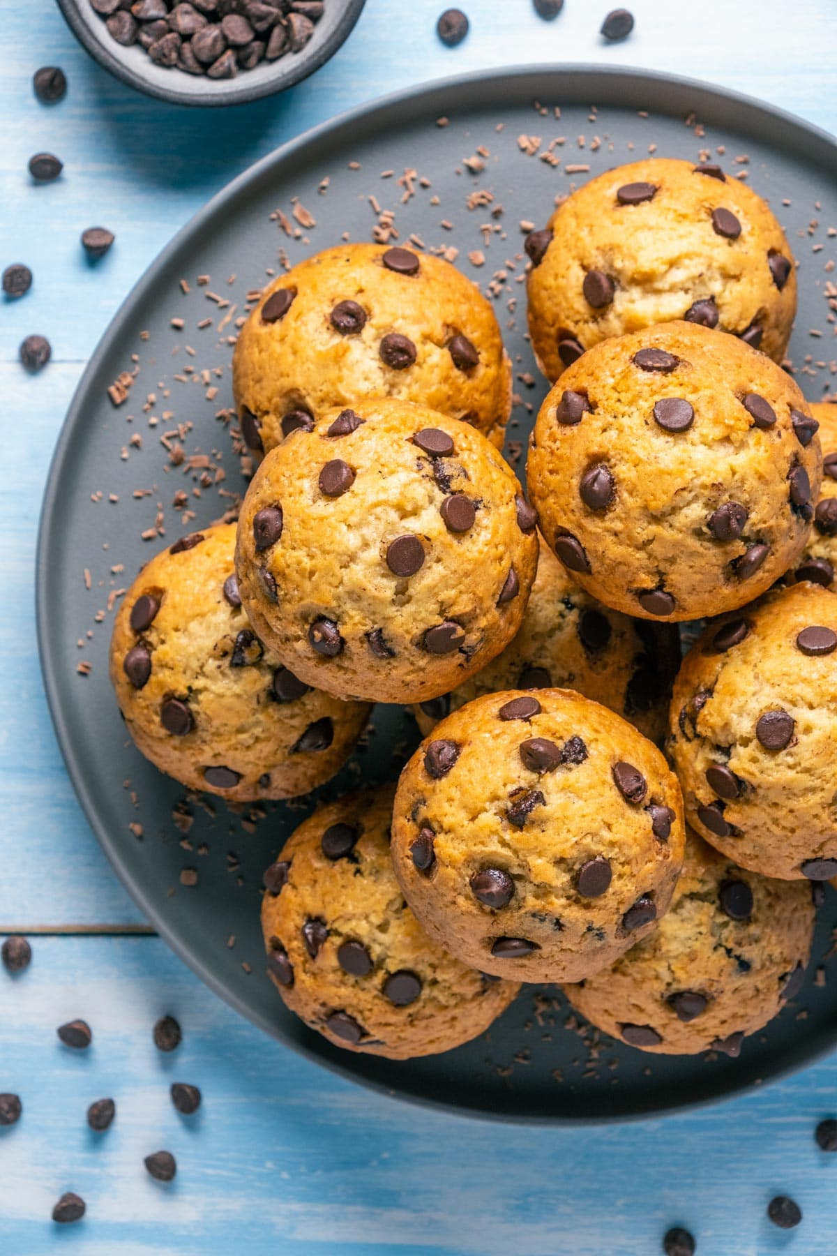 Vegan chocolate chip muffins stacked up on a plate.