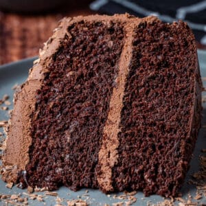 Slice of vegan chocolate fudge cake on a gray plate.