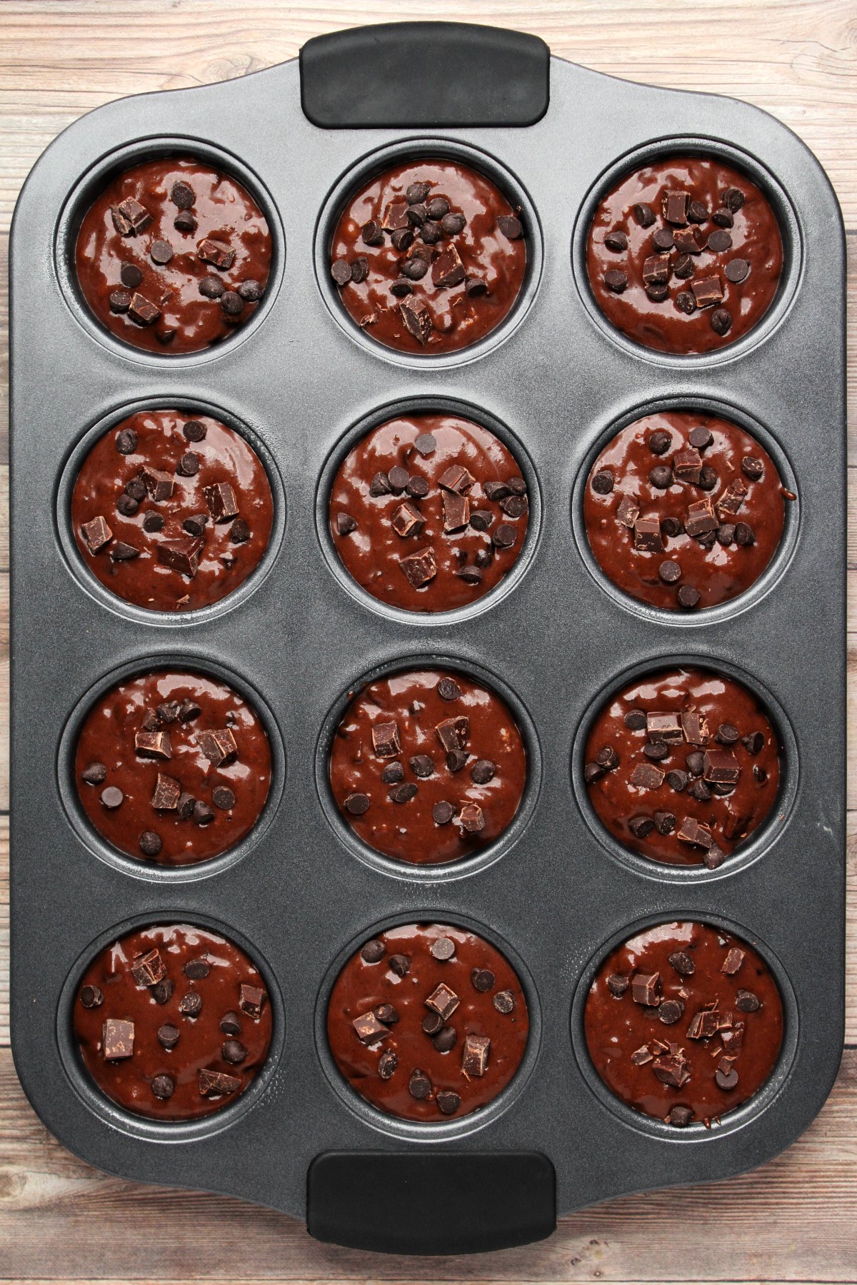 Muffin batter in a muffin tray ready to go into the oven.