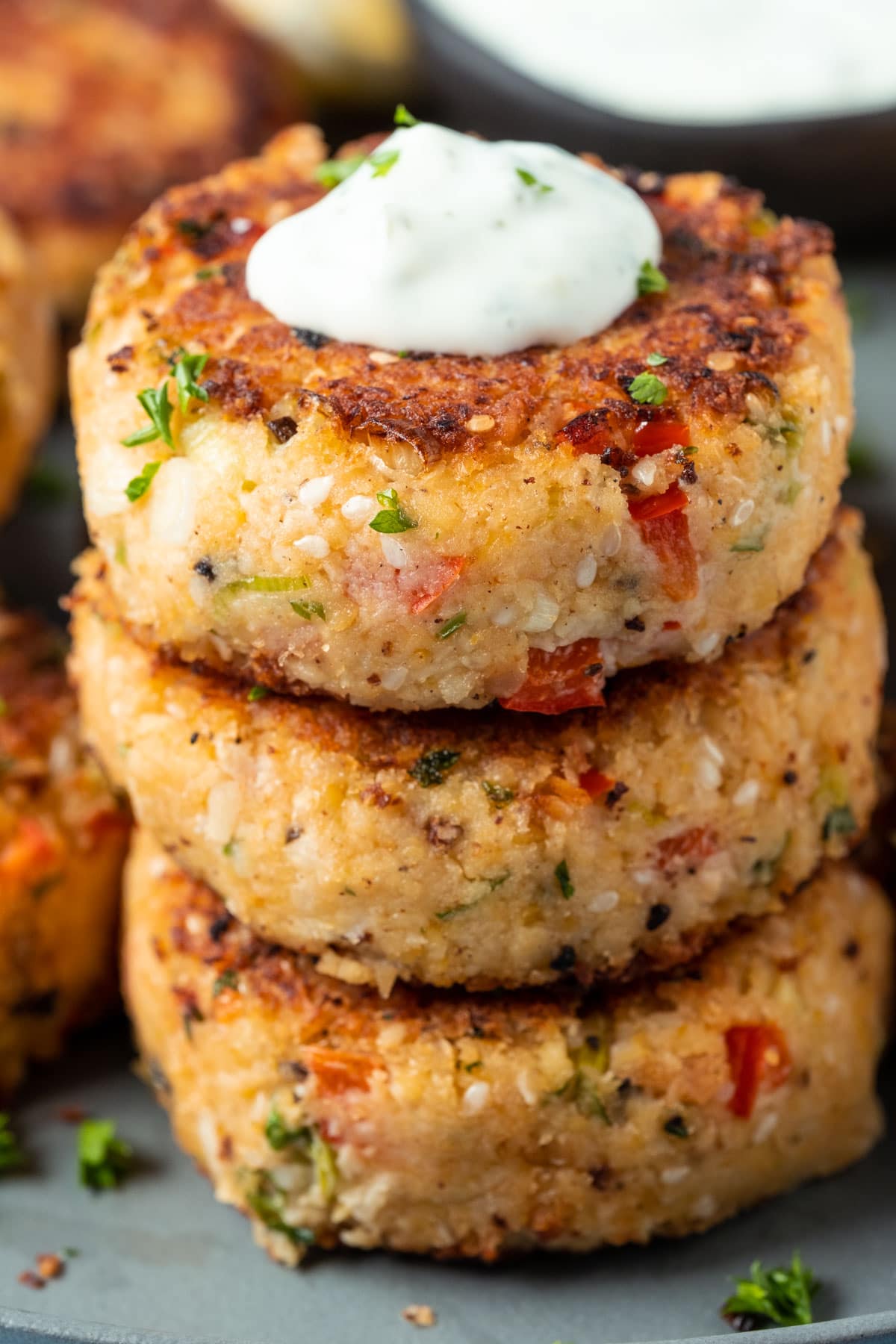 Stack of vegan crab cakes topped with vegan tartar sauce.