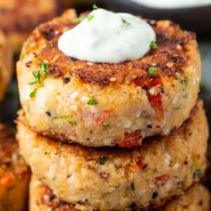 Stack of vegan crab cakes topped with vegan tartar sauce.