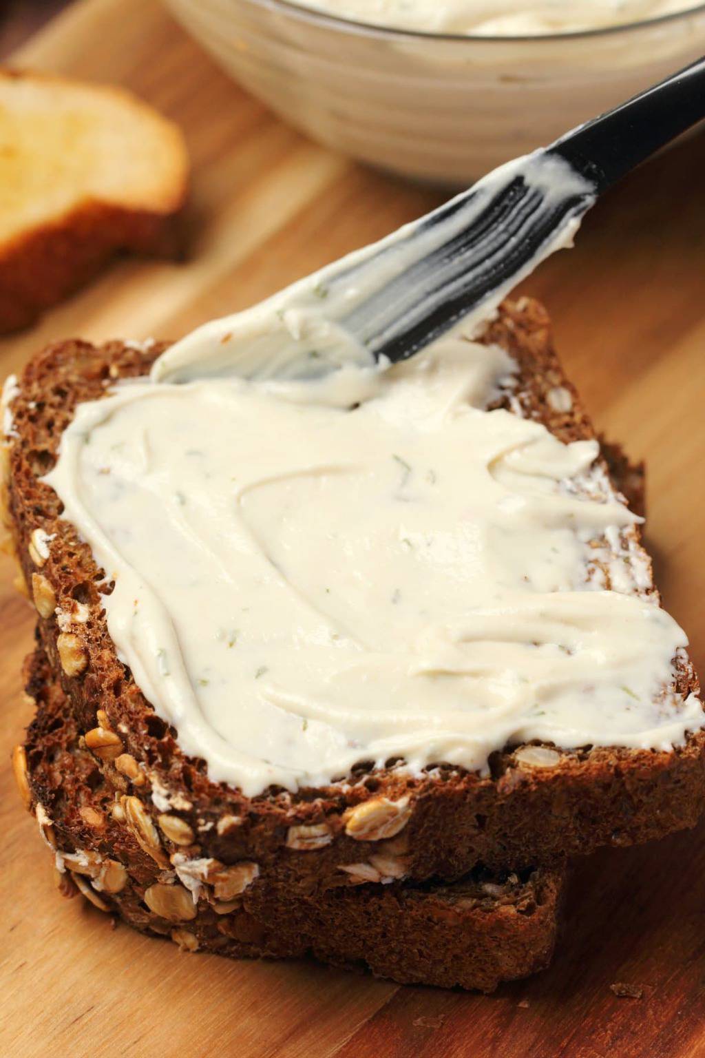 Vegan cream cheese spread on a slice of whole wheat bread. 