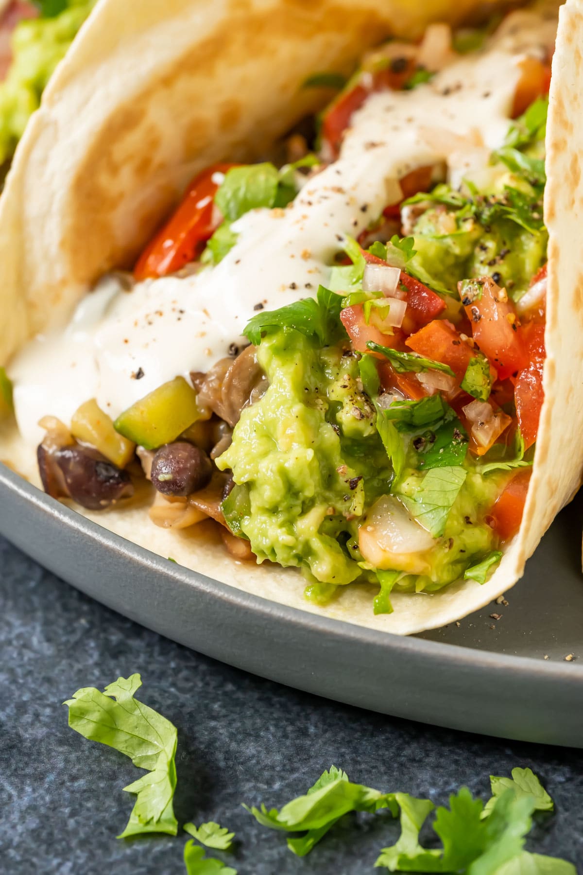 Fully loaded vegan fajitas on a gray plate.