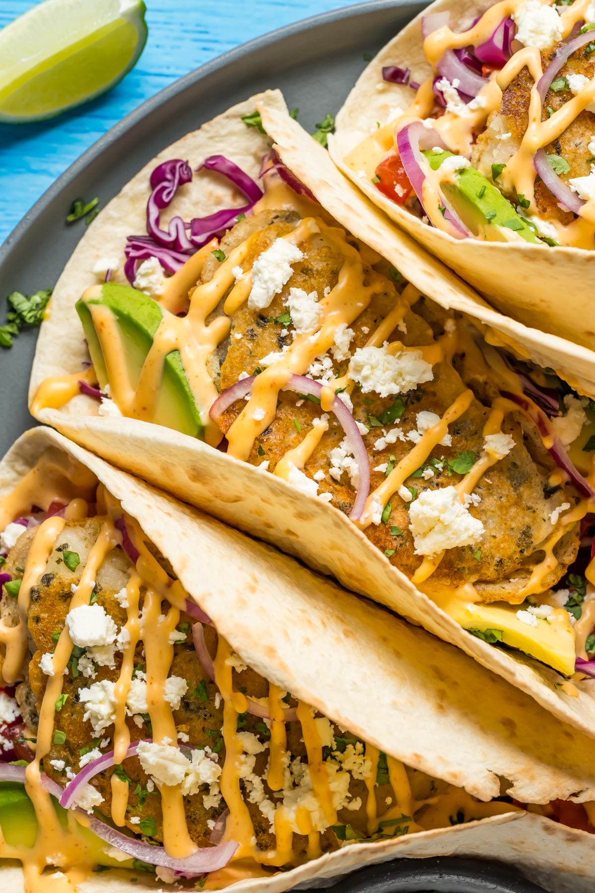 Vegan fish tacos on a gray plate.