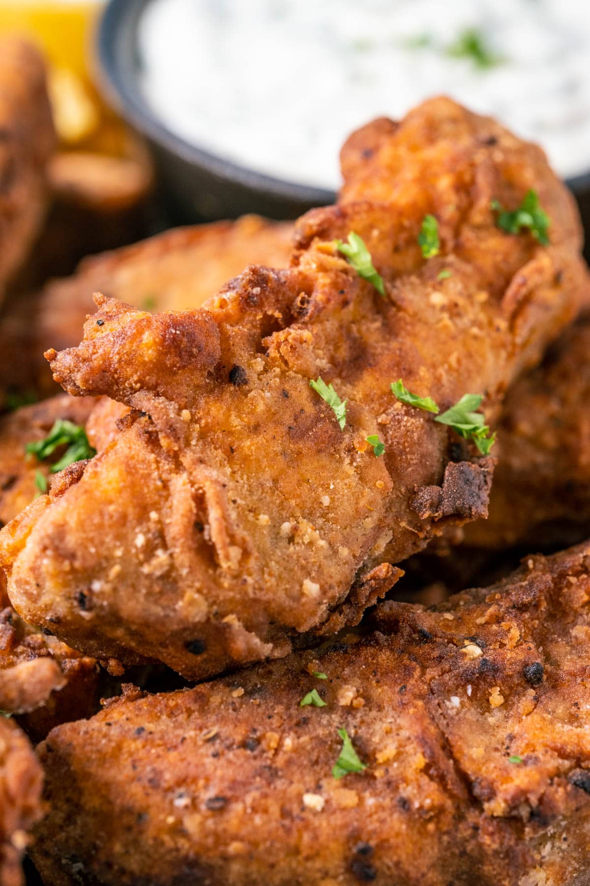 Vegan fried chicken pieces on a plate with vegan ranch dressing and chips.