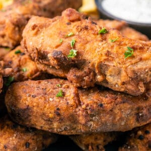 Vegan fried chicken stacked up on a plate.