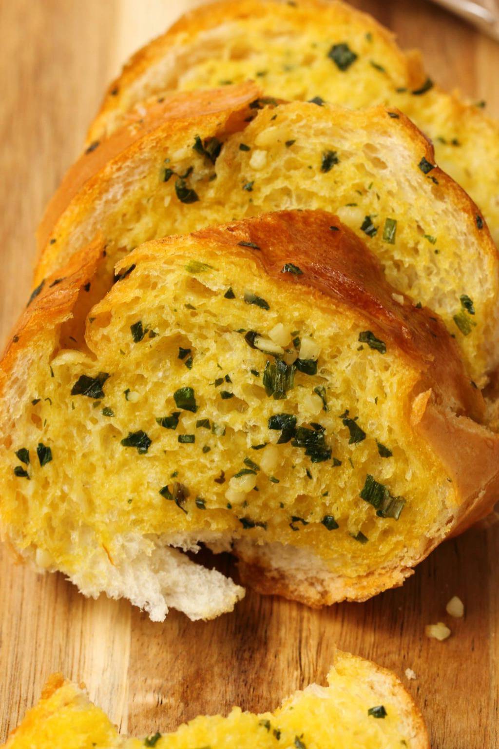 Vegan garlic bread on a wooden cutting board. 