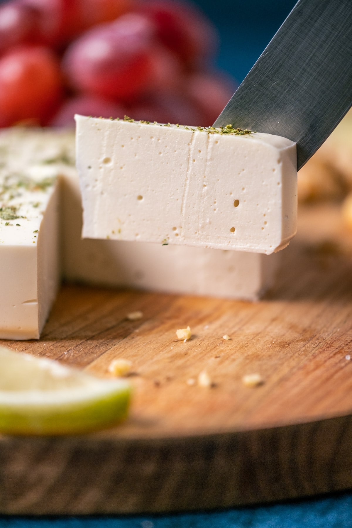 Slice of vegan goat cheese on a knife.