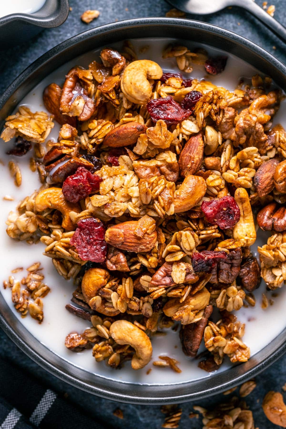 Vegan granola with almond milk in a black bowl.