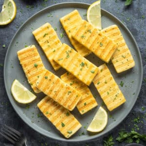 Slices of grilled vegan halloumi on a gray plate.