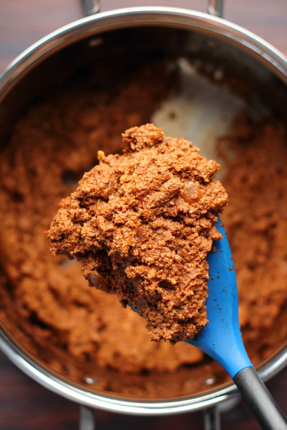 Vegan bolognese sauce in a pot with a spatula.