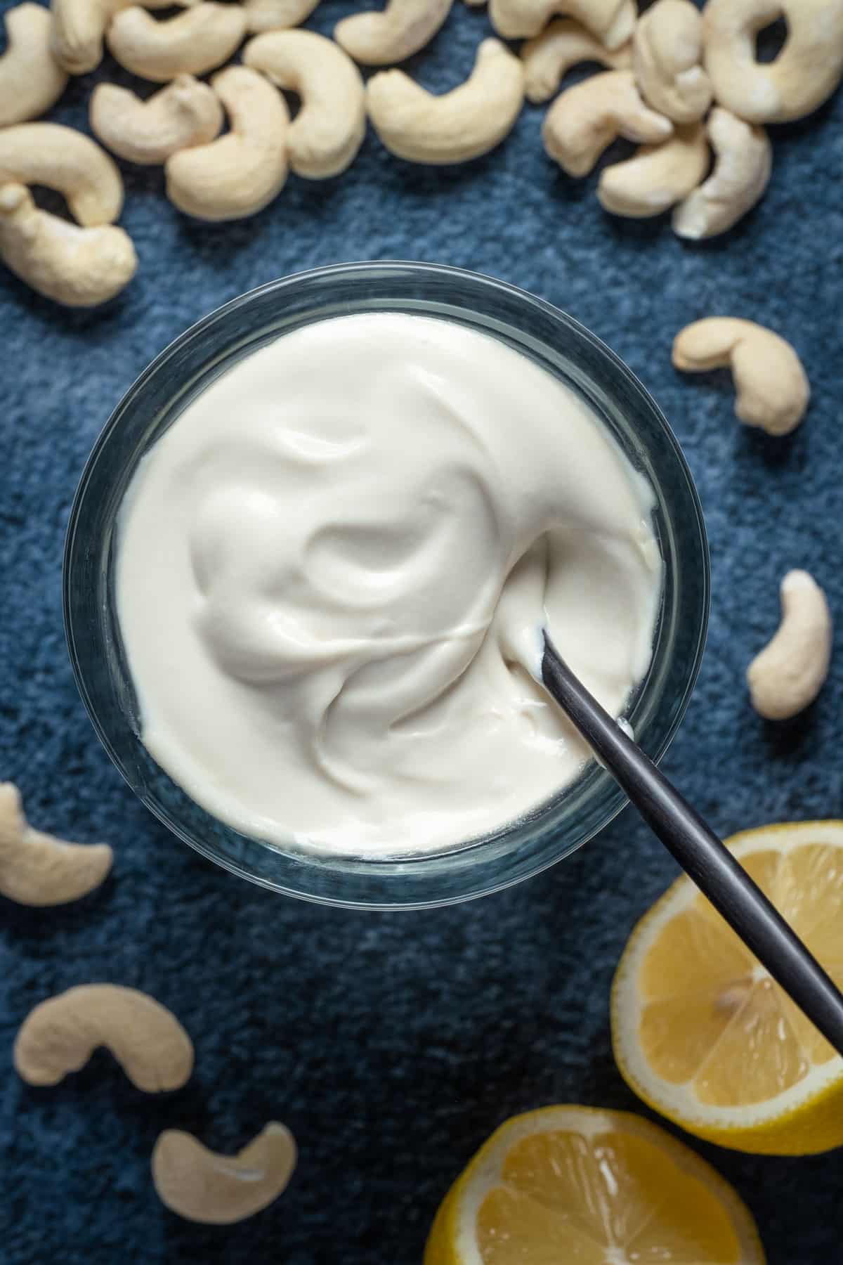 Vegan mascarpone in a glass jar with a spoon.