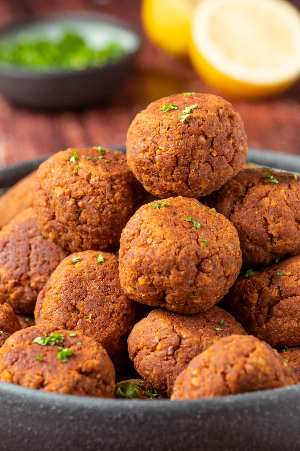 Vegan meatballs stacked up on a plate.