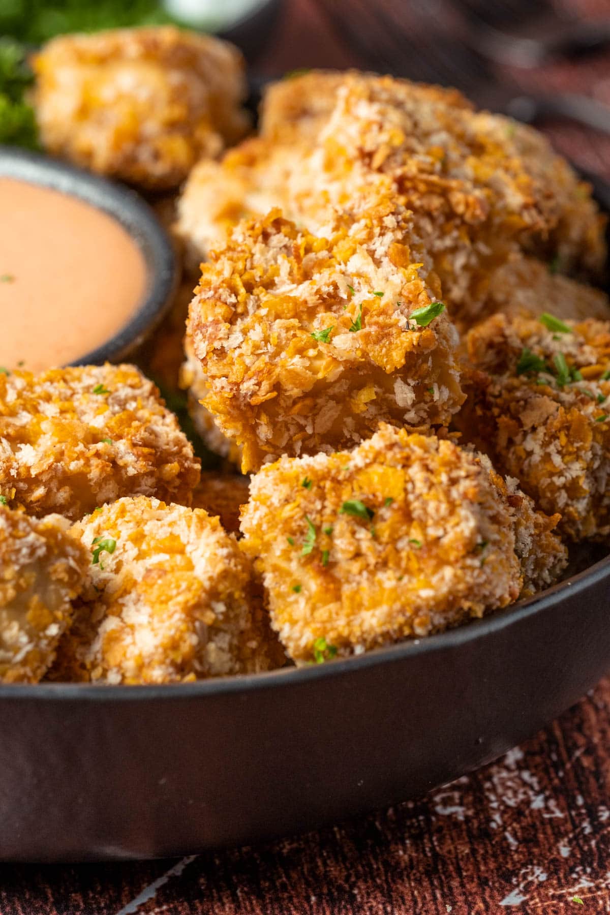 Vegan chicken nuggets stacked up on a plate.