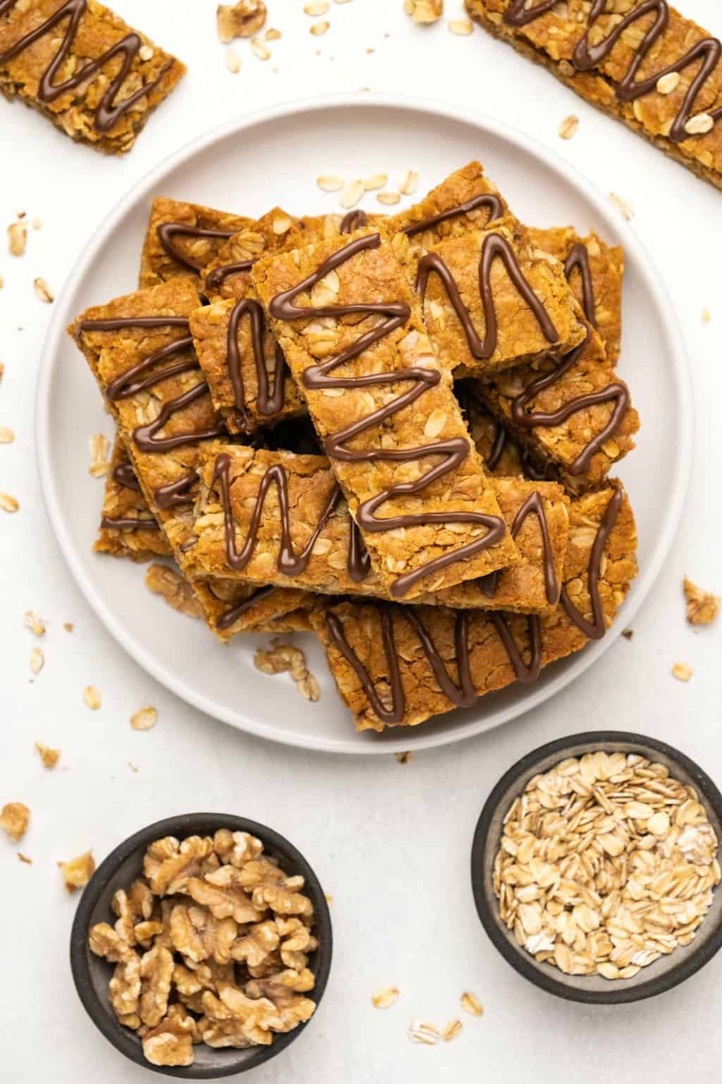 Vegan oatmeal bars stacked up on a white plate. 