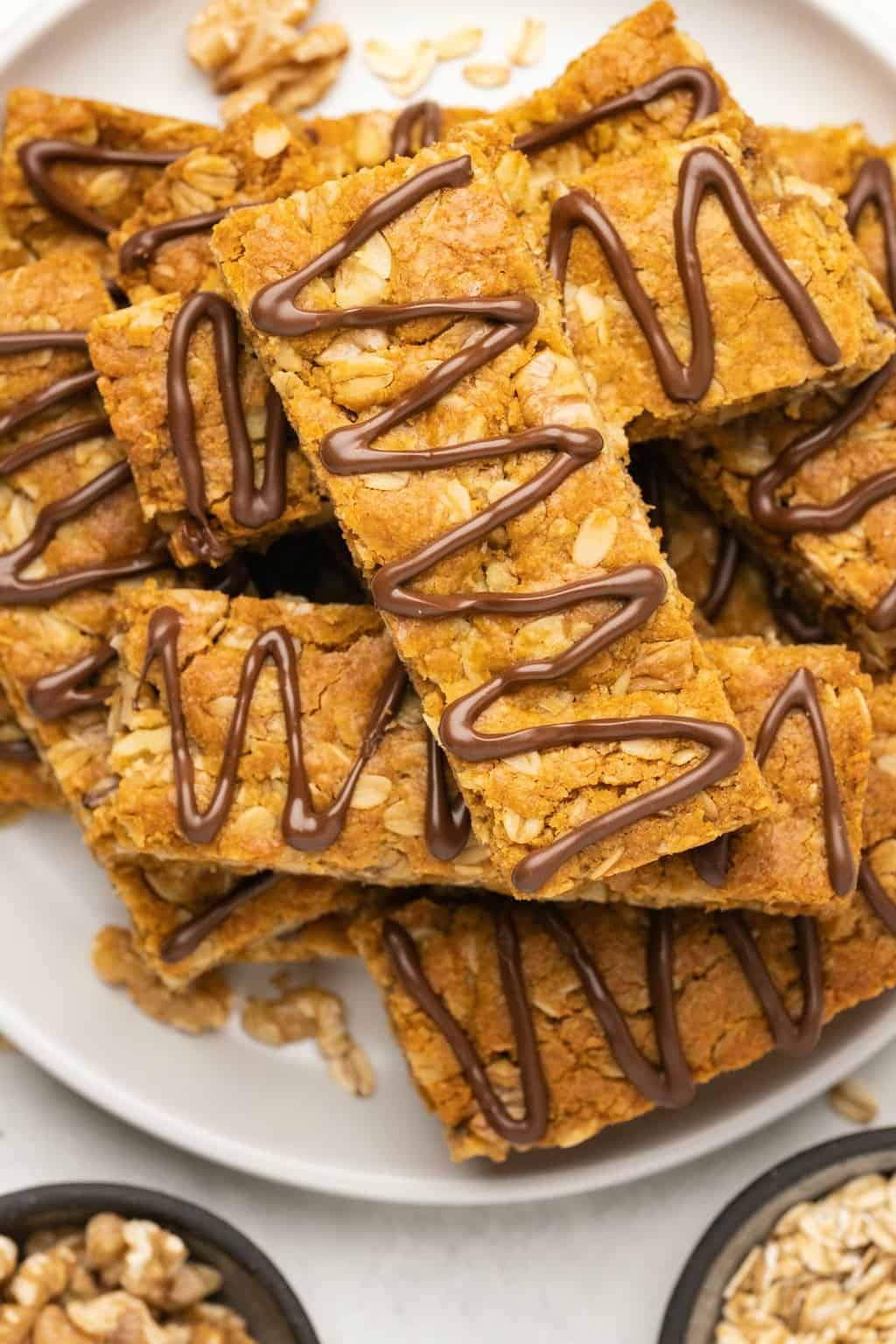 Vegan oatmeal bars stacked up on a white plate. 