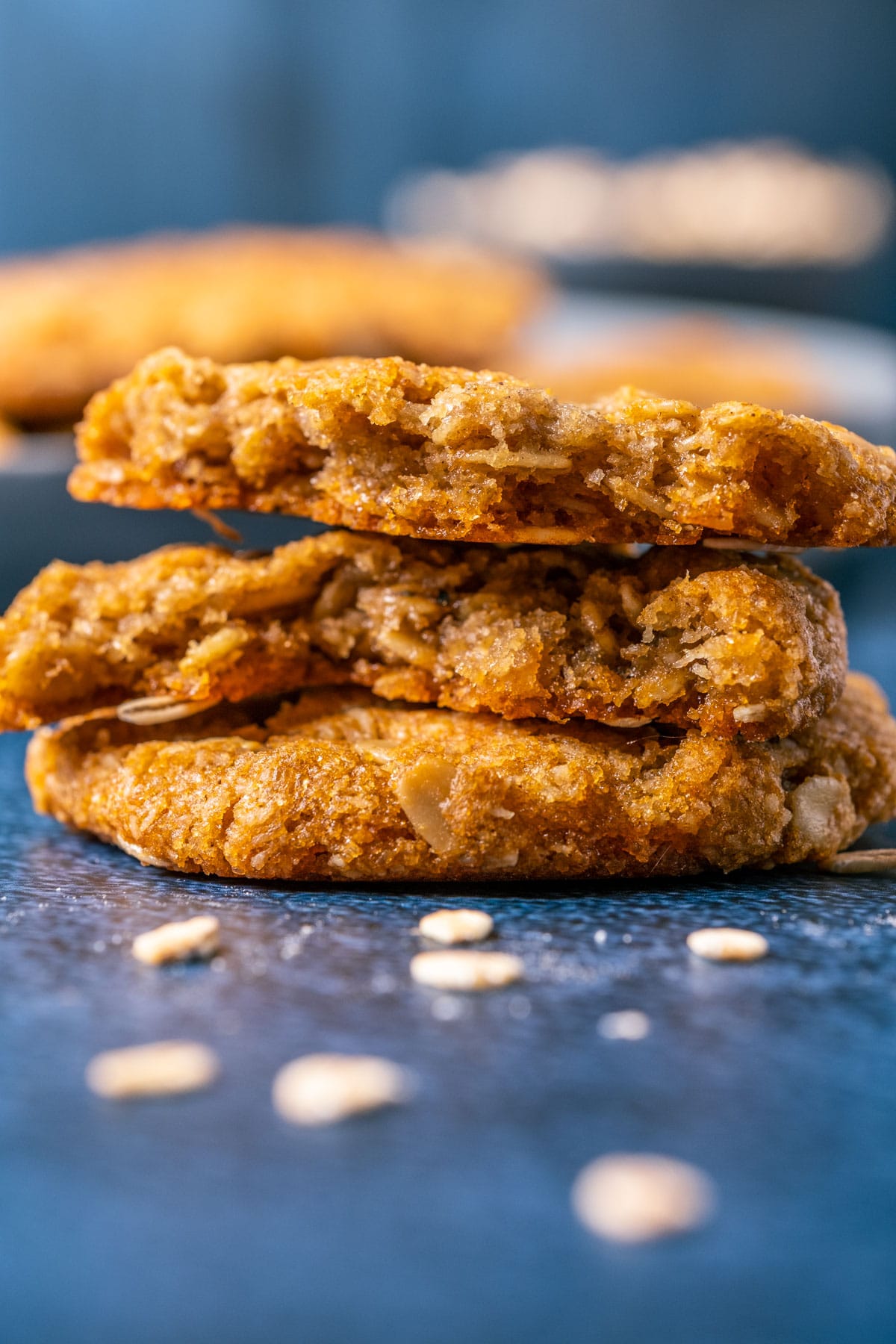 Oatmeal cookies in a stack with the top cookie broken in half.