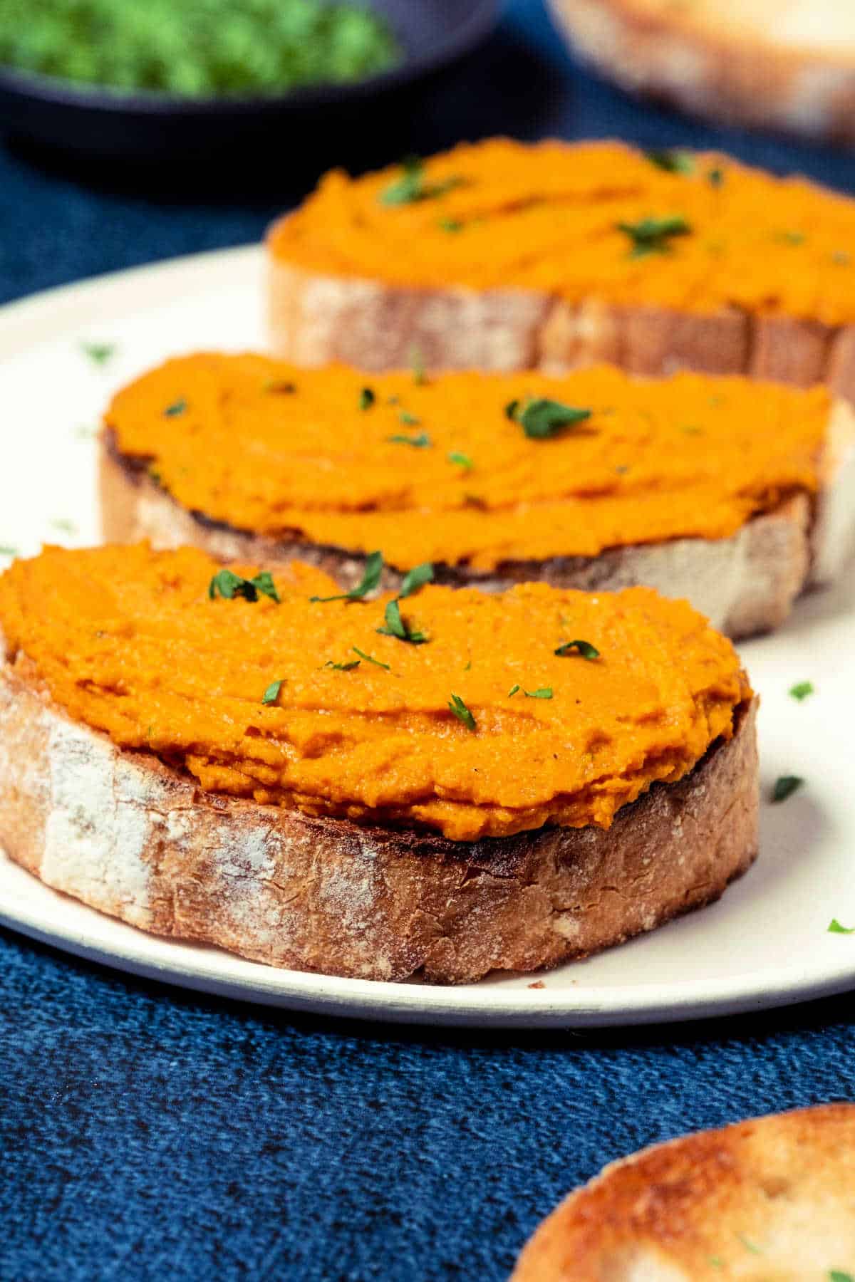 Slices of toast spread with vegan pâté on a white plate.