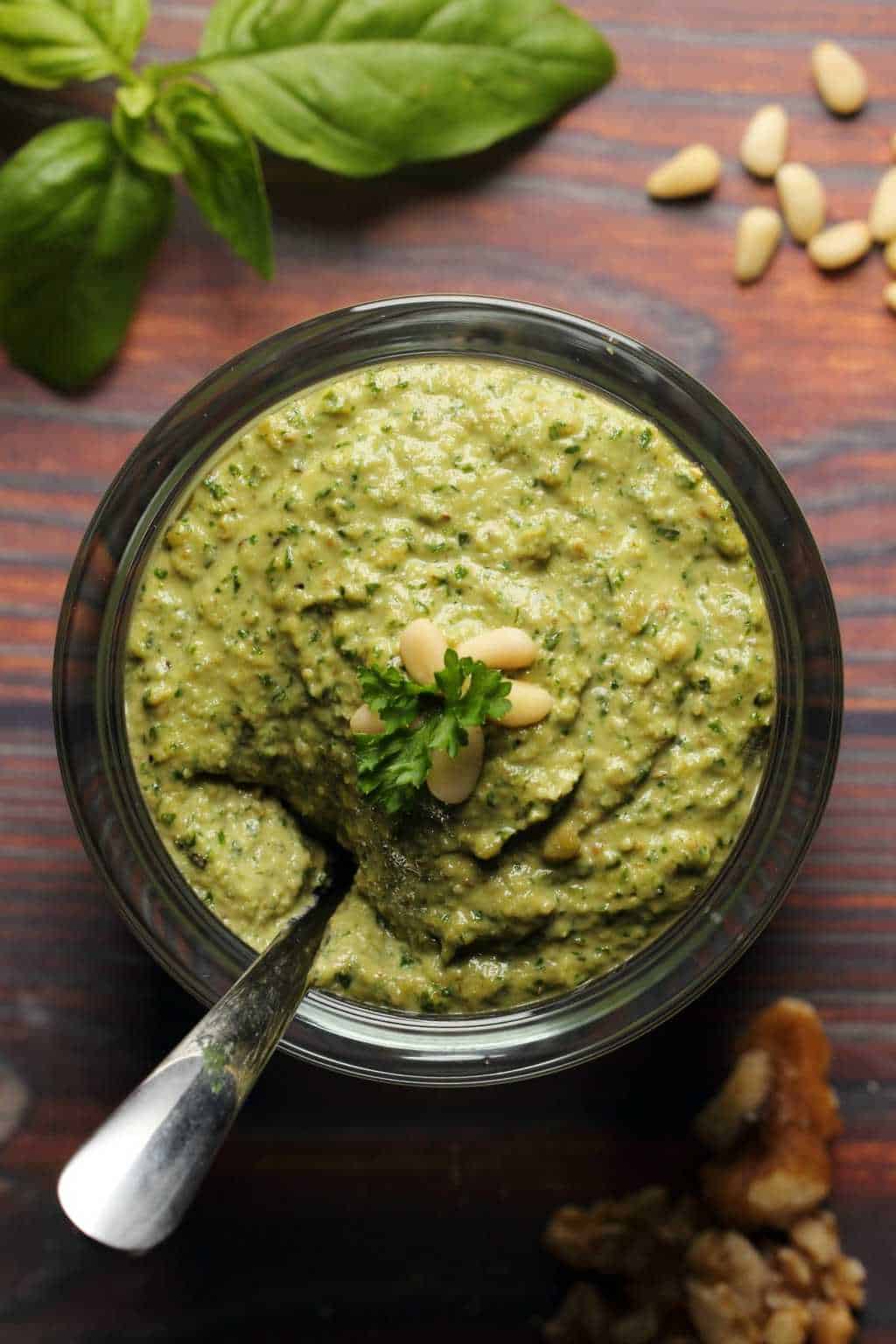 Vegan pesto in a glass jar with a spoon. 