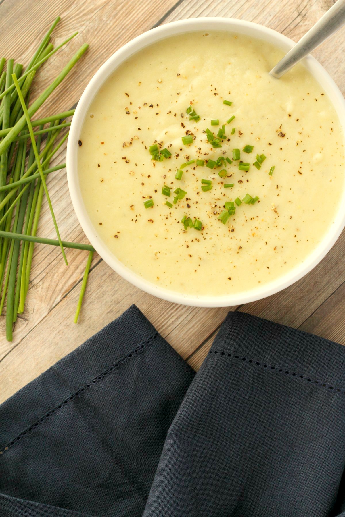 Vegan potato leek soup in a white bowl with a spoon. 