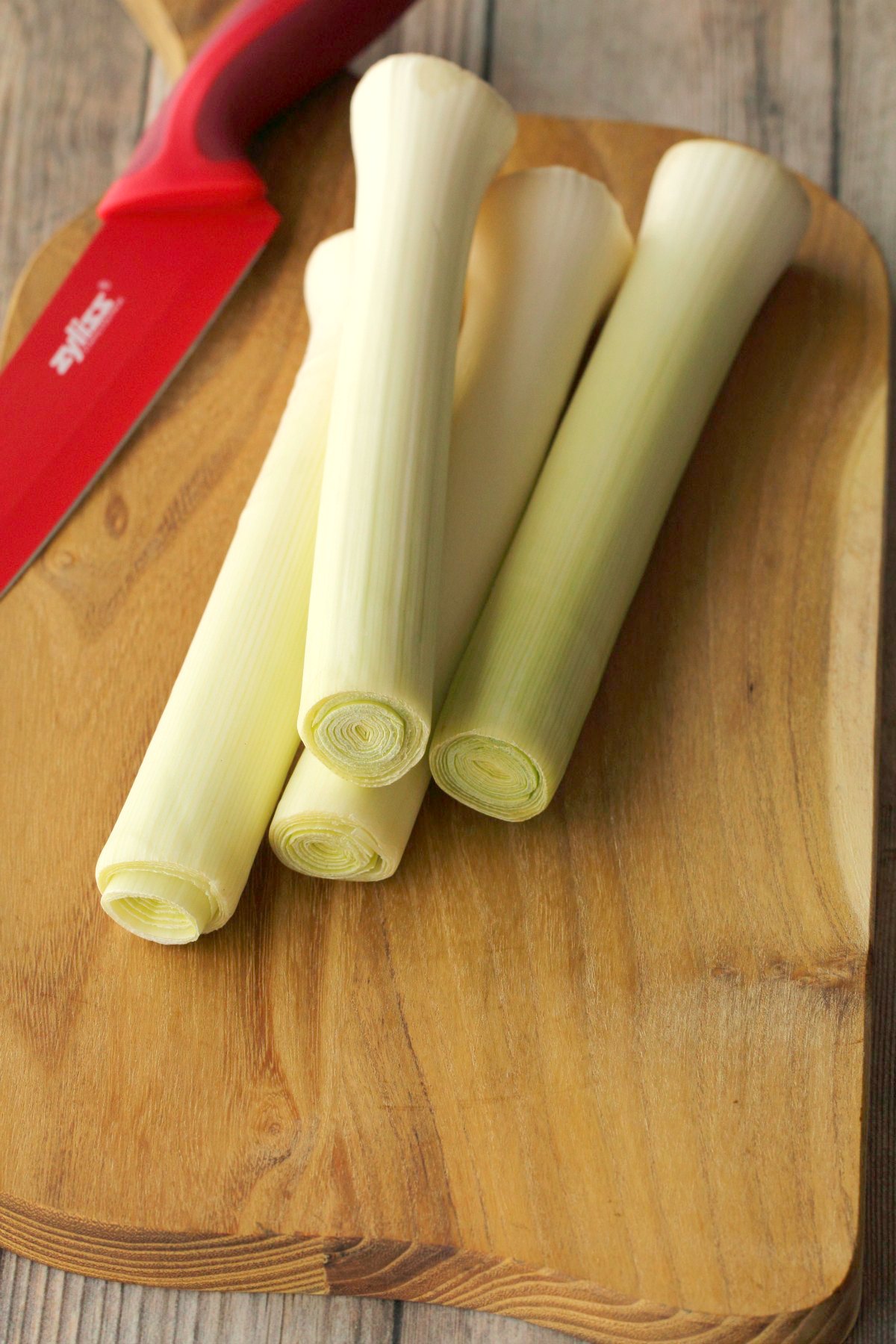 Leeks on a wooden chopping board. 