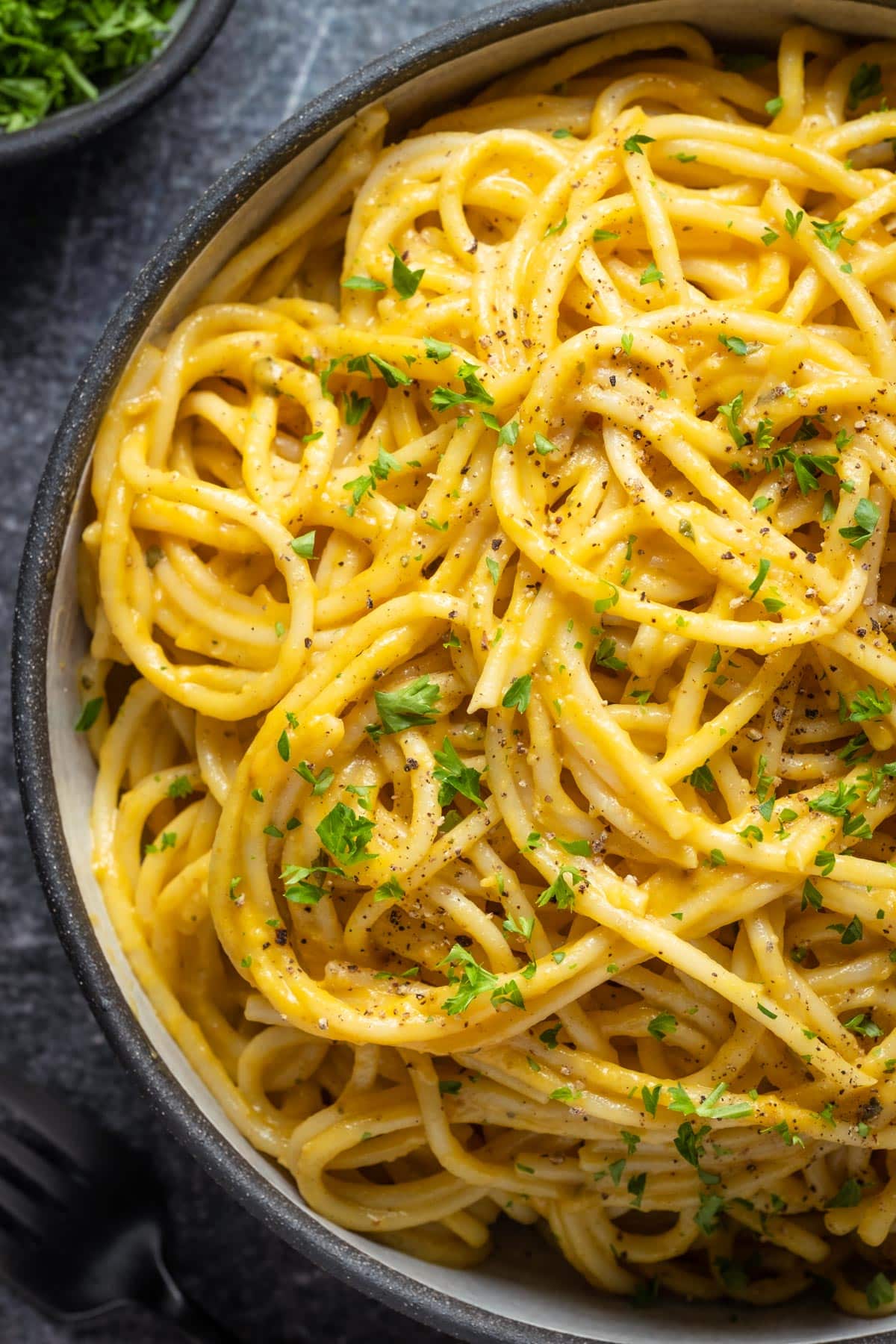 Pumpkin pasta topped with chopped parsley and ground black pepper.