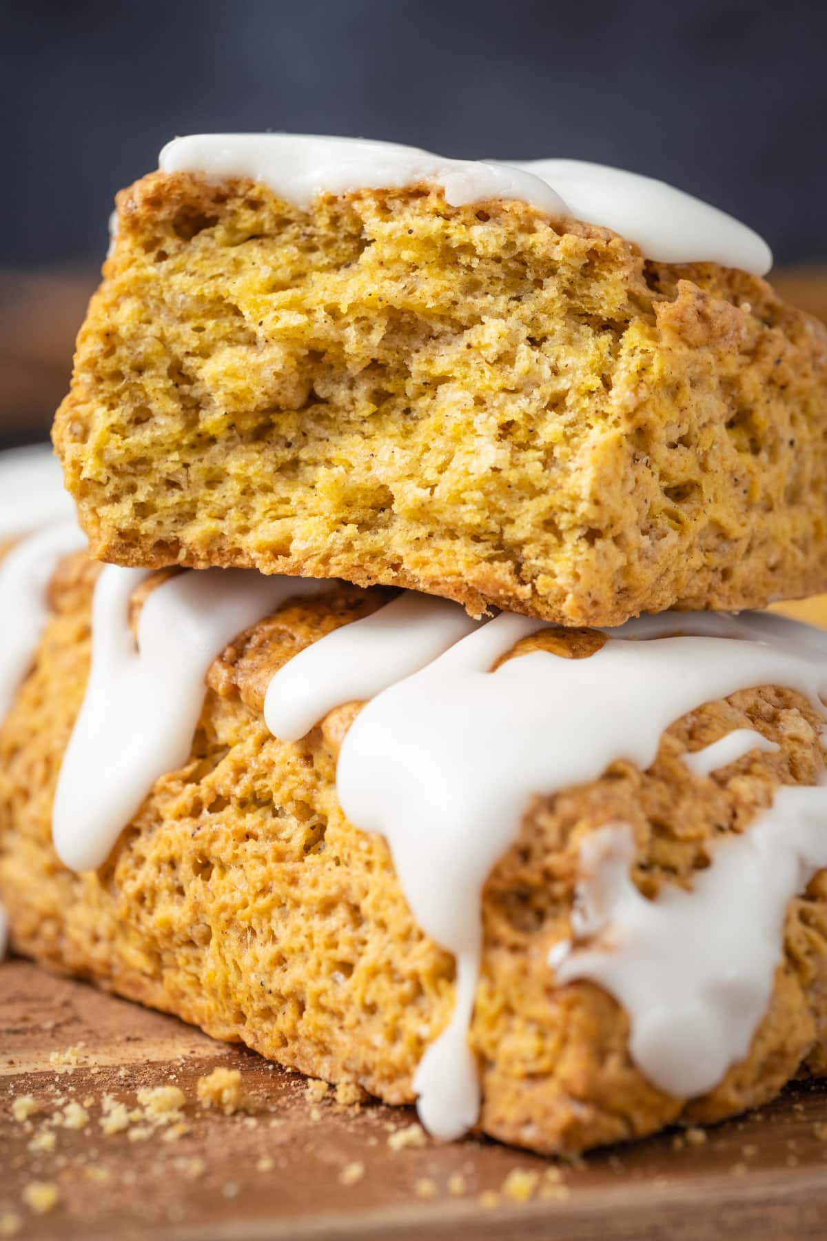 Stack of two pumpkin scones with the top scone broken in half.