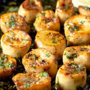 Vegan scallops with parsley in a frying pan.