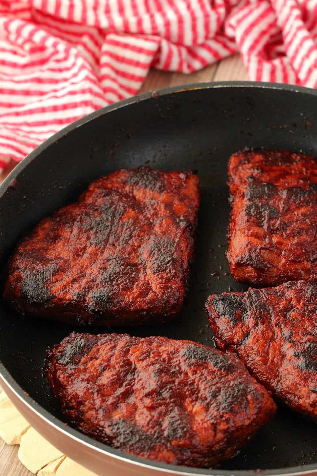 Vegan Steaks nicely charred and browned in a frying pan. 