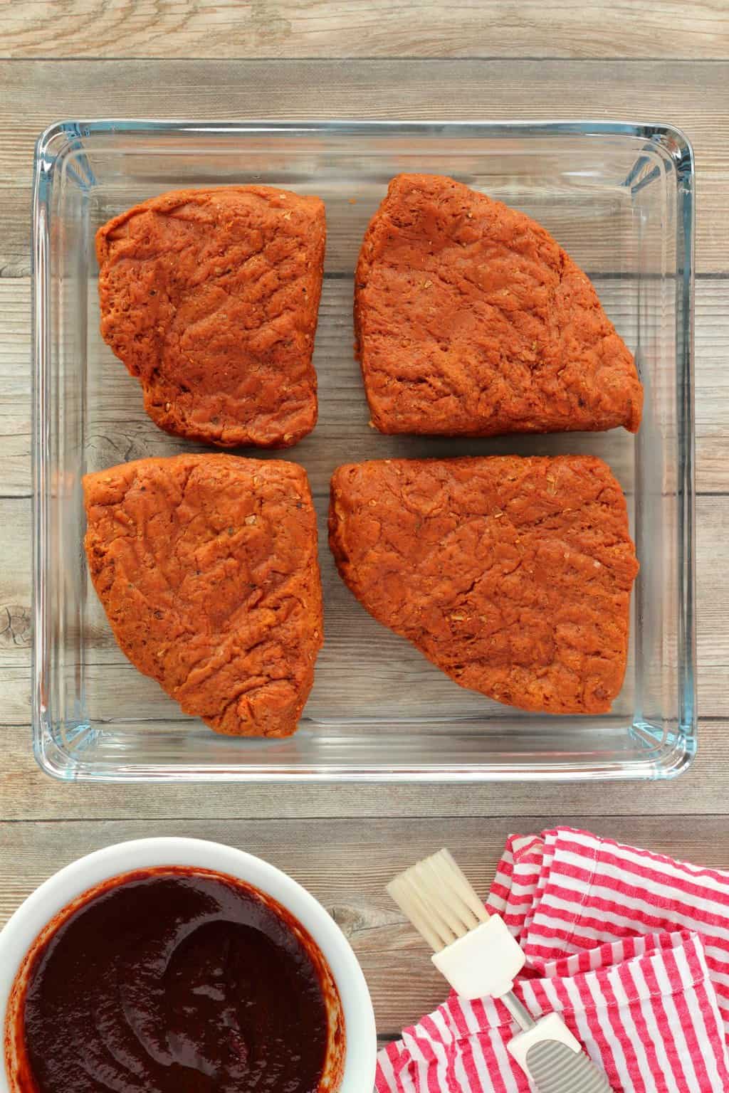 4 Vegan Steaks in a glass square dish. 