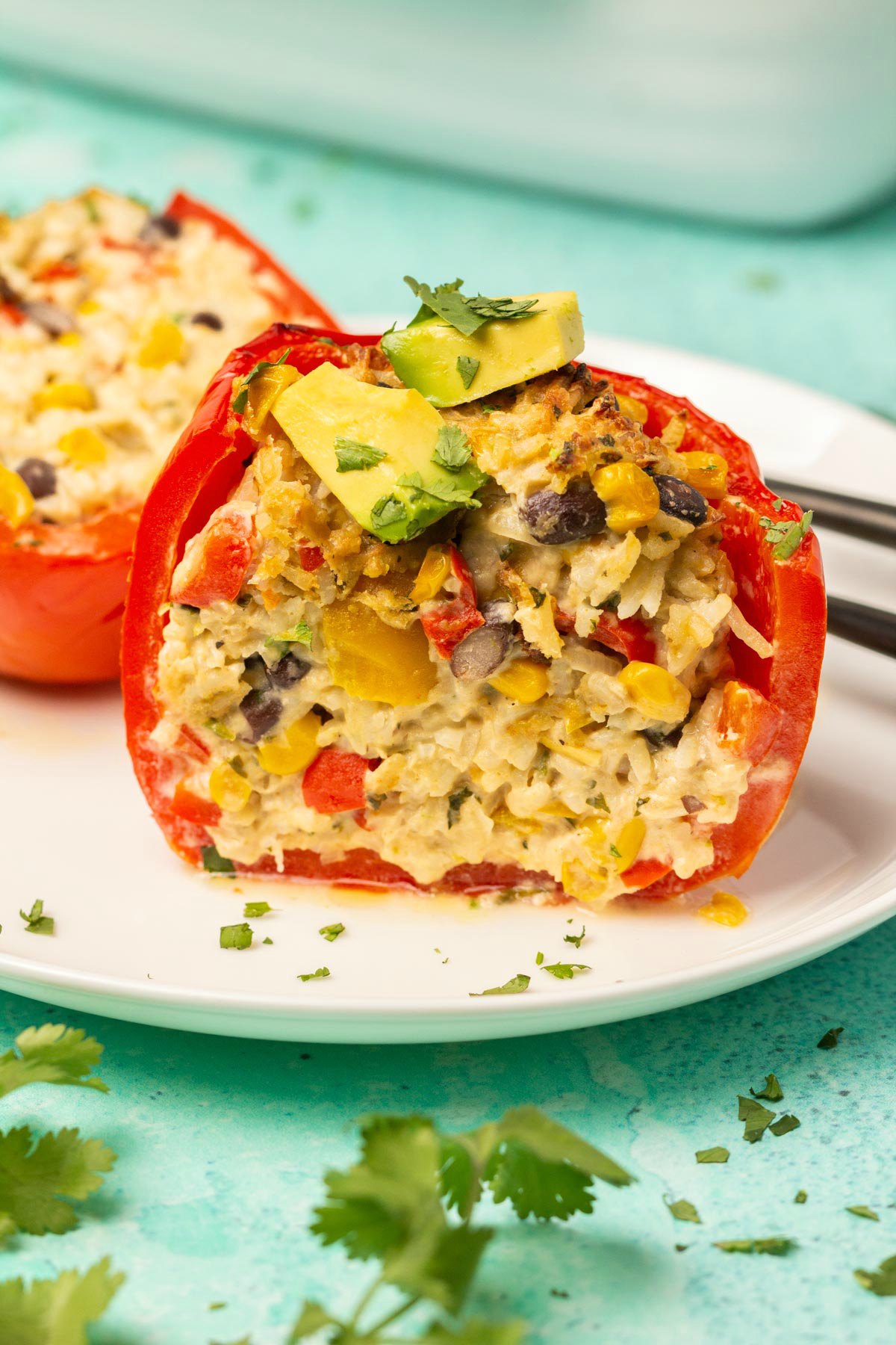 Vegan stuffed pepper cut in half on a white plate. 