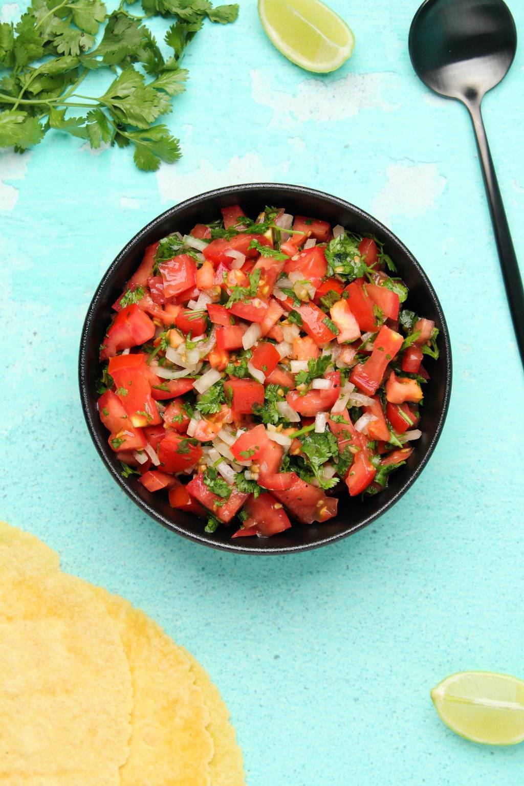 Pico de gallo salsa in a black bowl. 