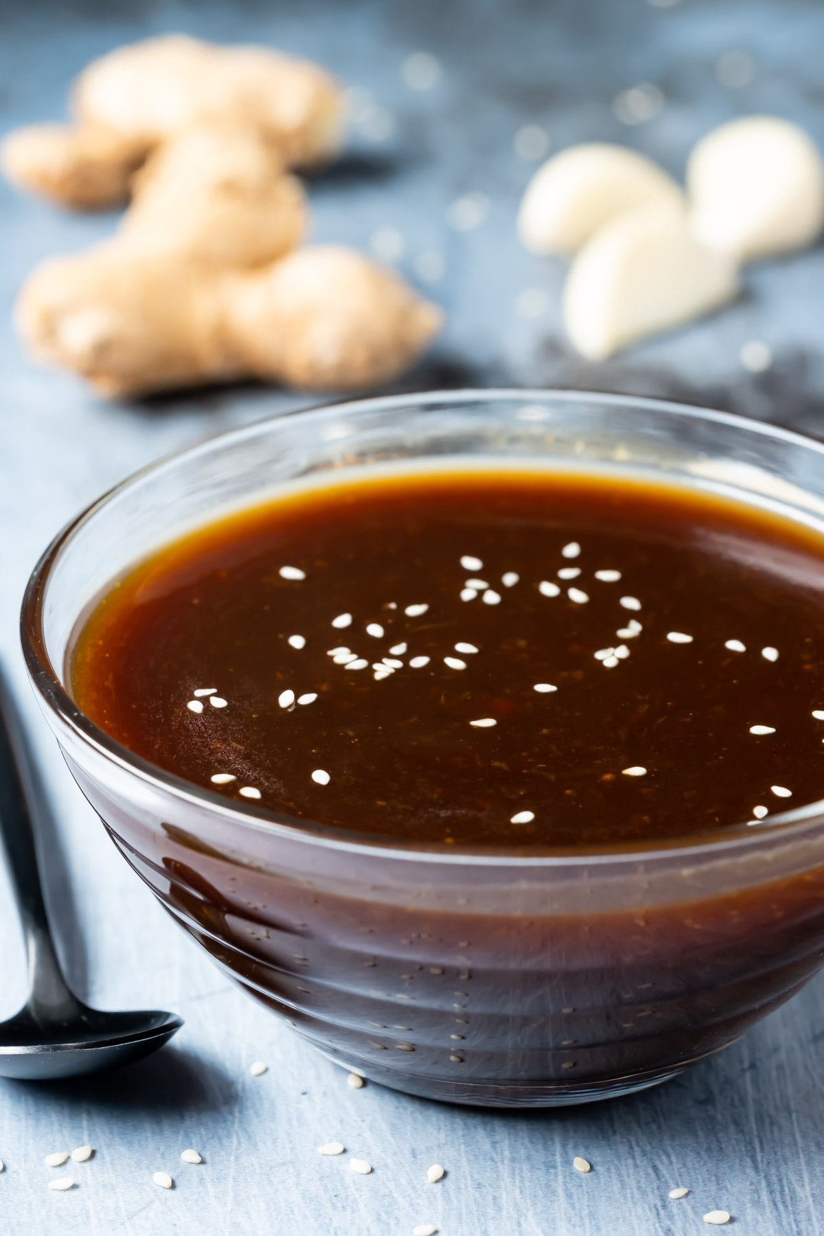 Vegan teriyaki sauce topped with sesame seeds in a glass dish.