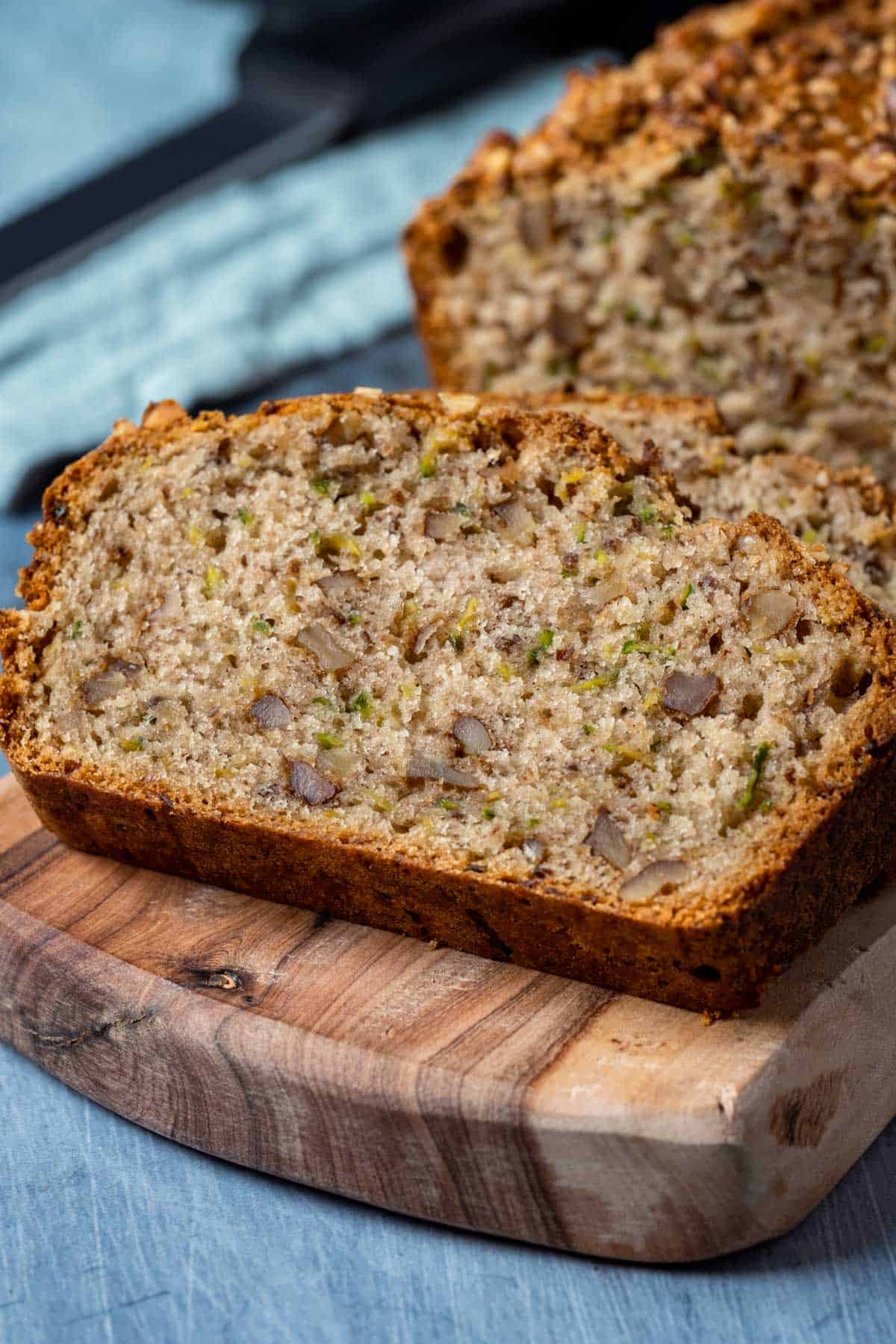 Slices of zucchini bread on a wooden board.