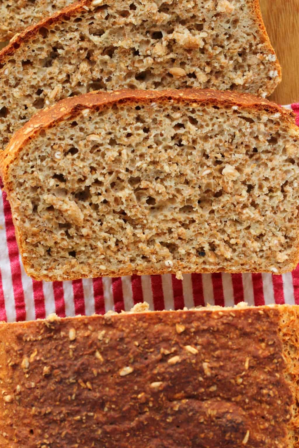 Wholewheat Bread slices on a wooden board with a red and white napkin. 